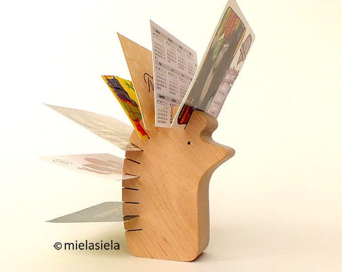 a wooden toy with scissors and paper sticking out of it's back end, on a white background