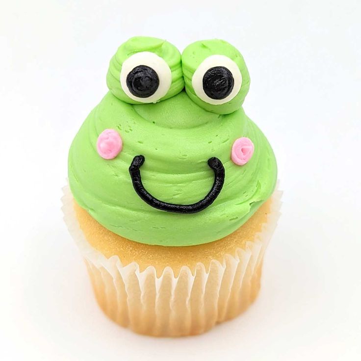 a cupcake with green frosting and googly eyes