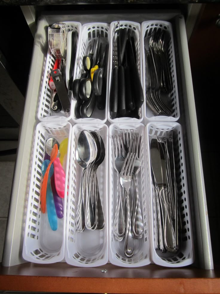 an organized drawer with utensils and spoons