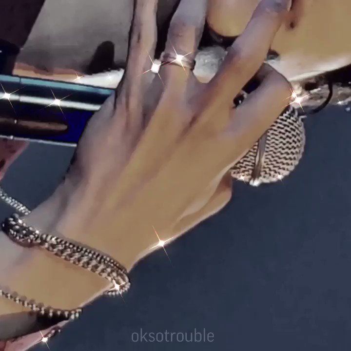 a woman's hand holding onto the handle of a motorcycle with chains on it