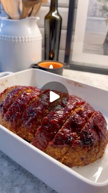 the meatloaf is covered with cranberry sauce and sits in a white casserole dish