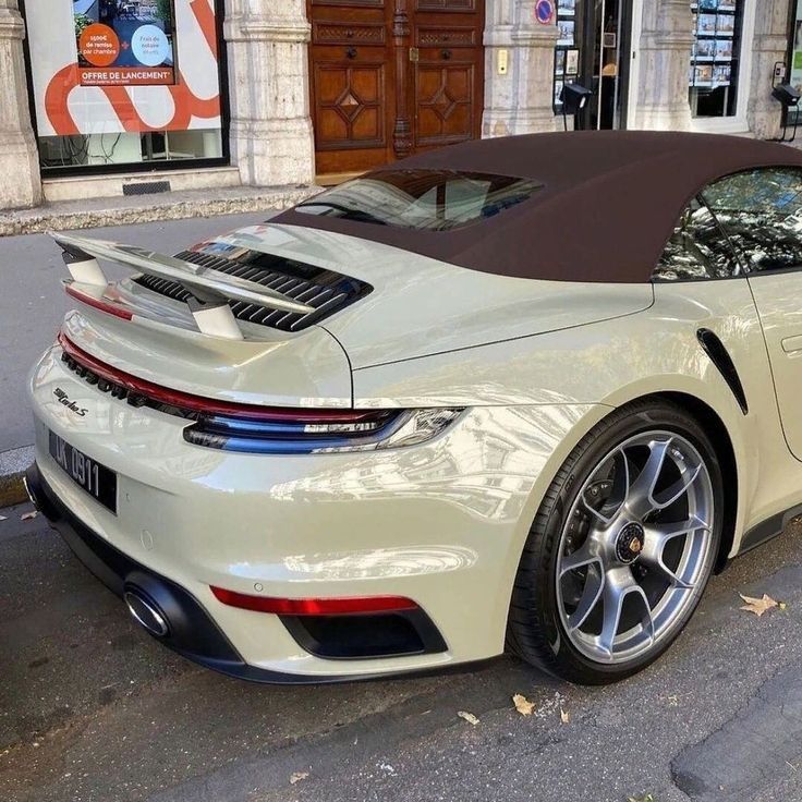 a white sports car parked in front of a building