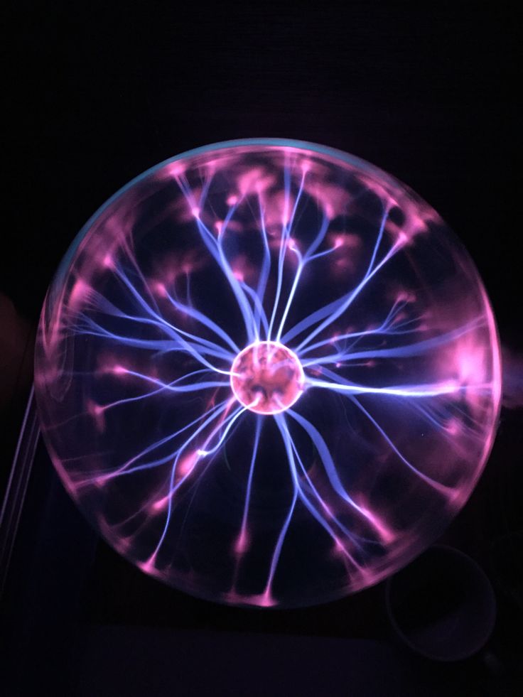 a glass plate with purple and blue lights in the center on a black background,