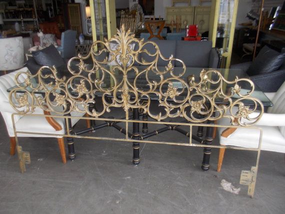 an ornate gold metal bed frame sitting on top of a white couch