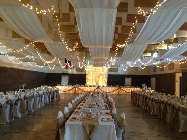 the banquet hall is decorated with white linens and draping