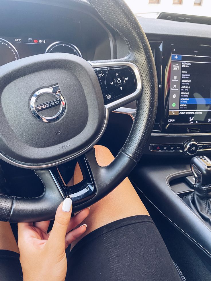 a woman sitting in the driver's seat of a car