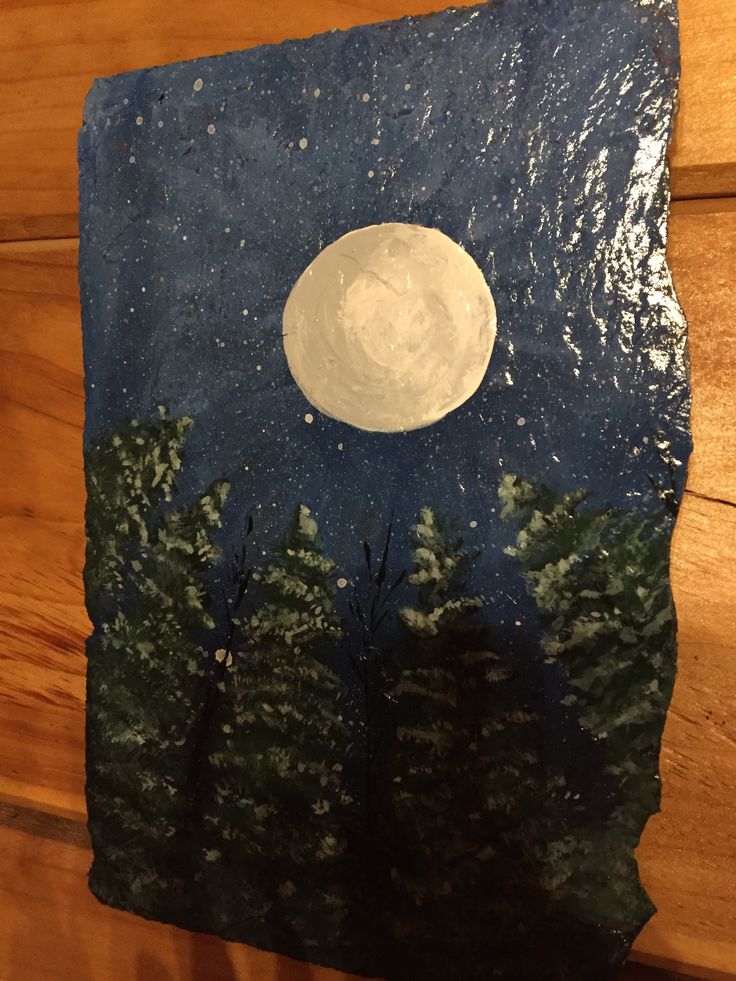 a night scene painted on a piece of wood with trees and the moon in the sky