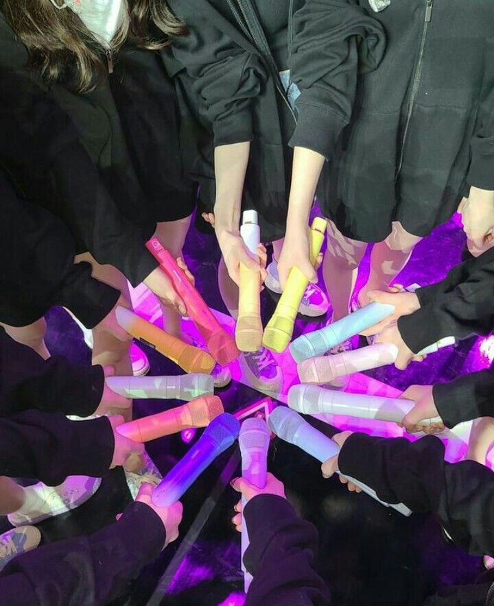 a group of people standing around each other with their hands in the middle of them