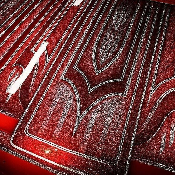 the interior of a car with red paint and chrome trims, including an emblem on the hood