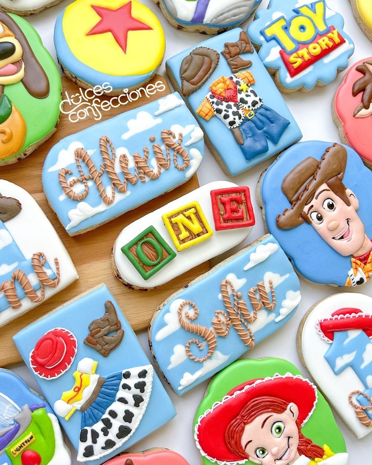 many decorated cookies on a table with toy story characters in the top one is blue and white