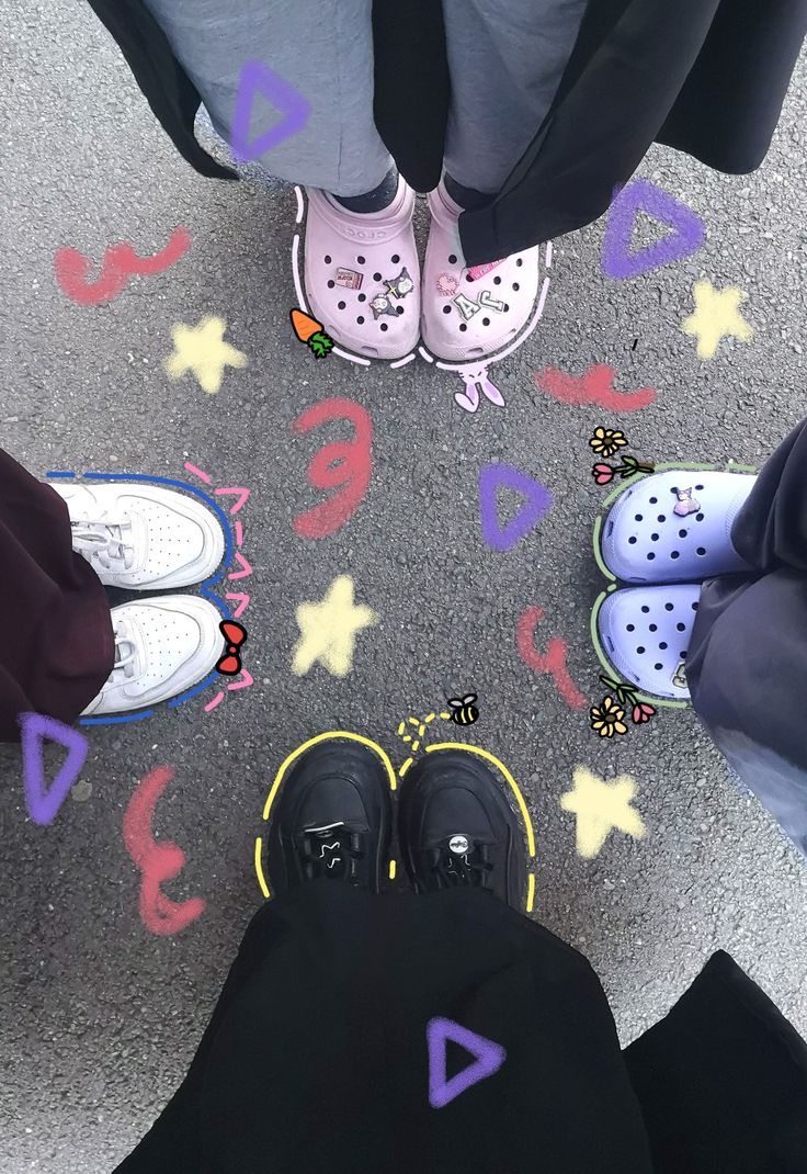 four people standing in a circle with their feet on the ground and one person wearing pink shoes