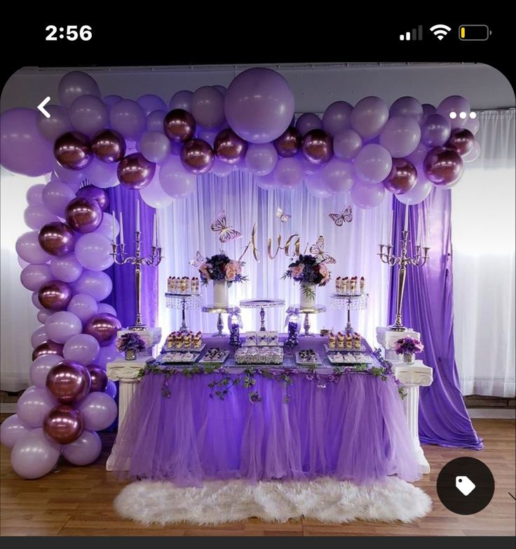 a purple and white dessert table with balloons