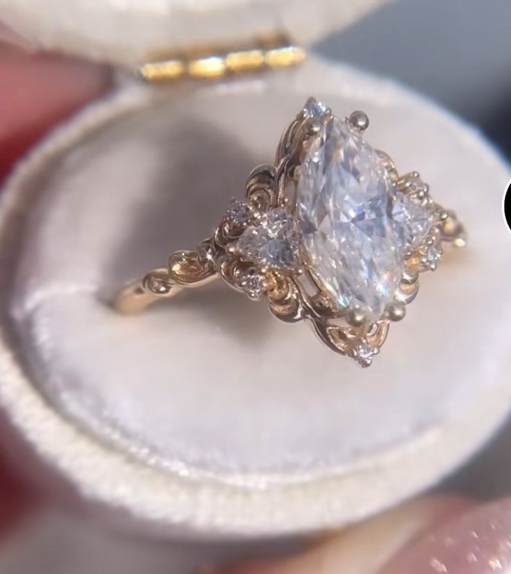 a close up of a person holding a ring with a diamond in it's center