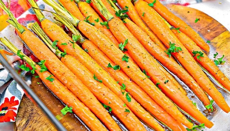 carrots with parsley on a wooden platter ready to be cooked in the oven