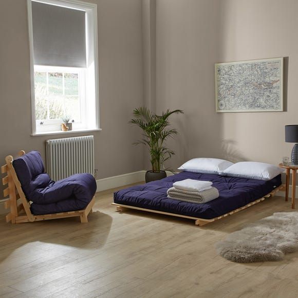 a bedroom with a bed, chair and rug in the corner next to a window