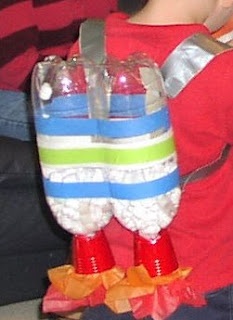 a young boy is holding an object made out of candy canes and plastic cups