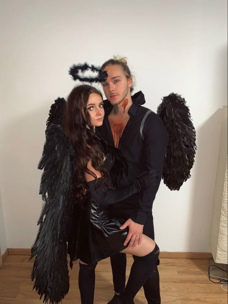 a man and woman dressed up in costumes posing for a photo with black feathers on their head