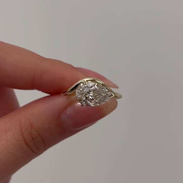 a person holding a diamond ring in their hand