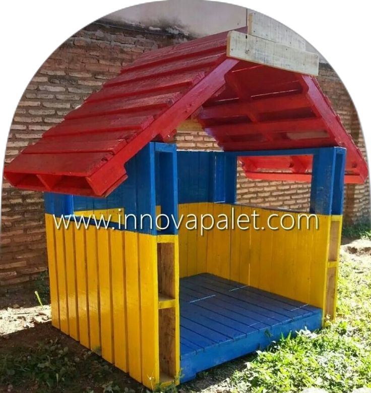 a child's play house made out of wooden pallets and painted in bright colors