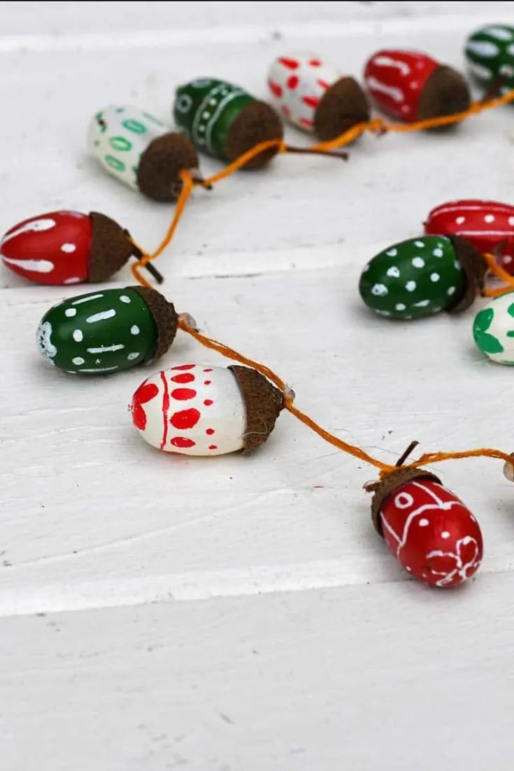 a string of painted eggs on a white table with red, green and white dots