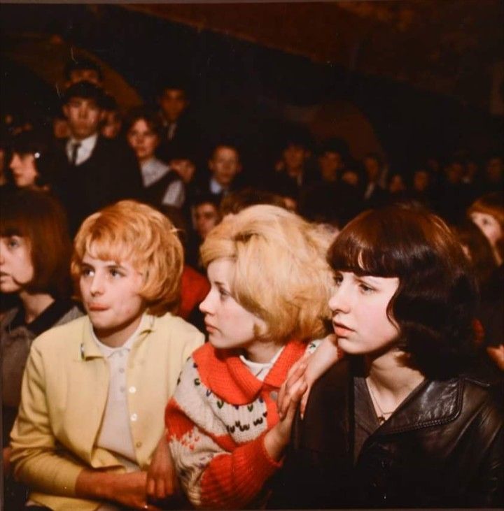 three women sitting next to each other in front of an audience at a movie theater