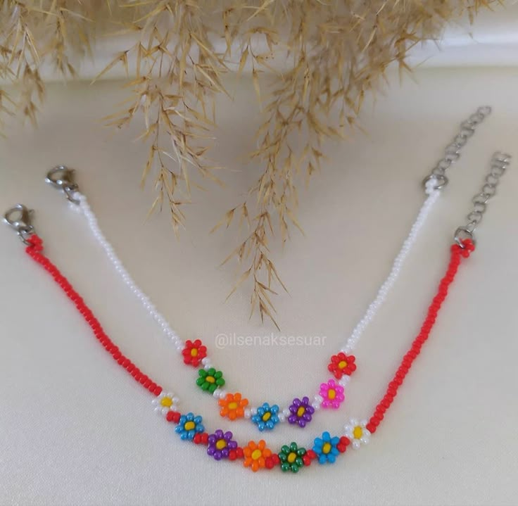 three beaded necklaces with flowers on them