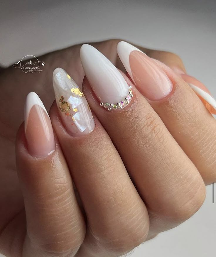 a woman's hand with some white and gold nails