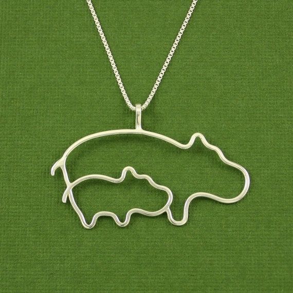 a silver necklace with an image of a bear in the shape of a fish on it