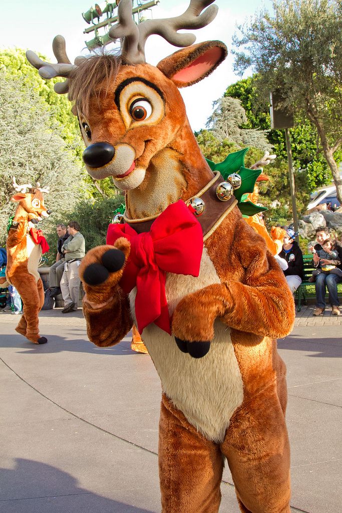 the reindeer is dressed up in costume and ready to dance with other people behind him