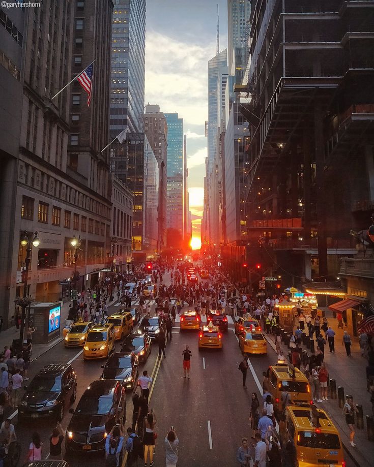 a city street filled with lots of traffic and people walking on the side of it