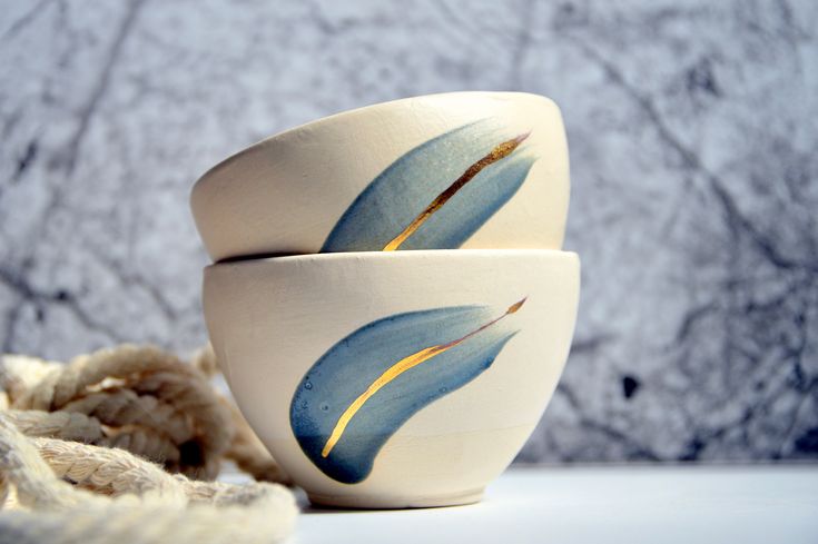 two white bowls with blue and yellow designs on them