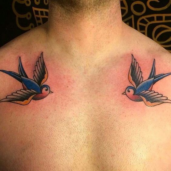 the back of a man's chest with two birds on it