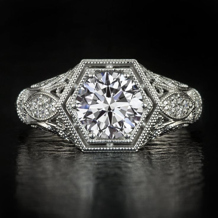 a diamond engagement ring with filigrees and diamonds on the sides, set in white gold