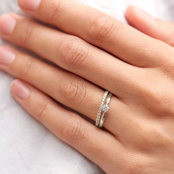 a woman's hand with a diamond ring on it