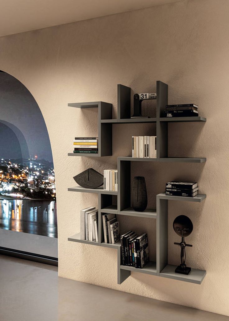 a book shelf with many books on it in front of a window overlooking the city