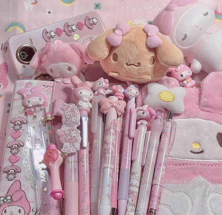 hello kitty stationery and accessories are laid out on a pink blanket with teddy bears