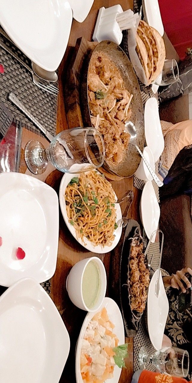 an overhead view of a table full of plates and bowls with food on them,