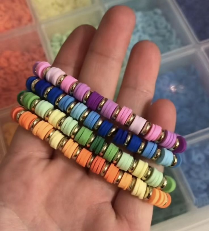 there is a hand that has some small beads in it and many colors are on the palm