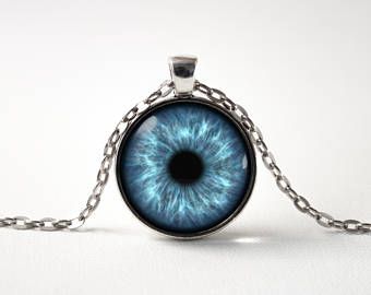 a blue eyeball necklace on a chain with a black hole in the center,