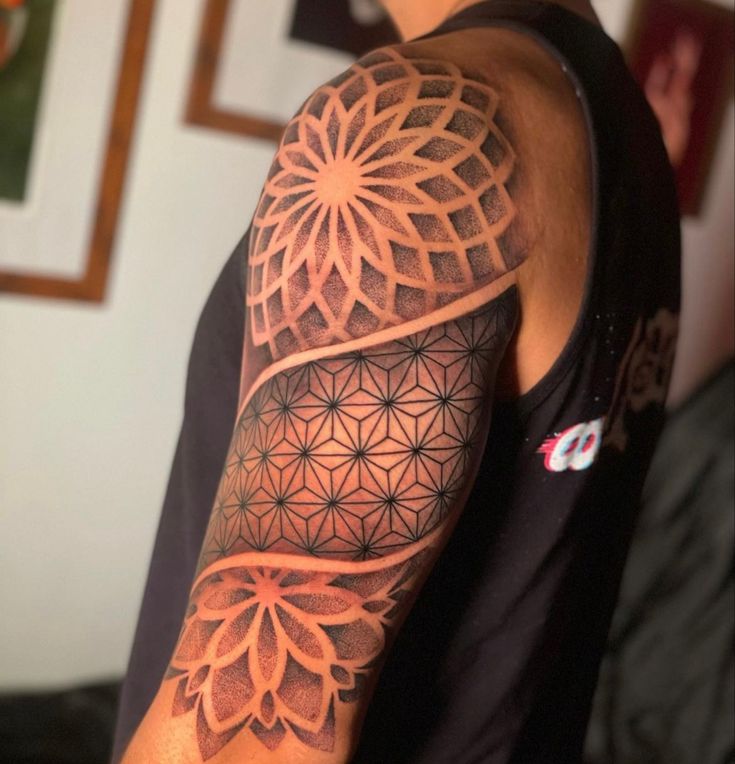 a man's arm with an intricate tattoo design on the arm and shoulder area