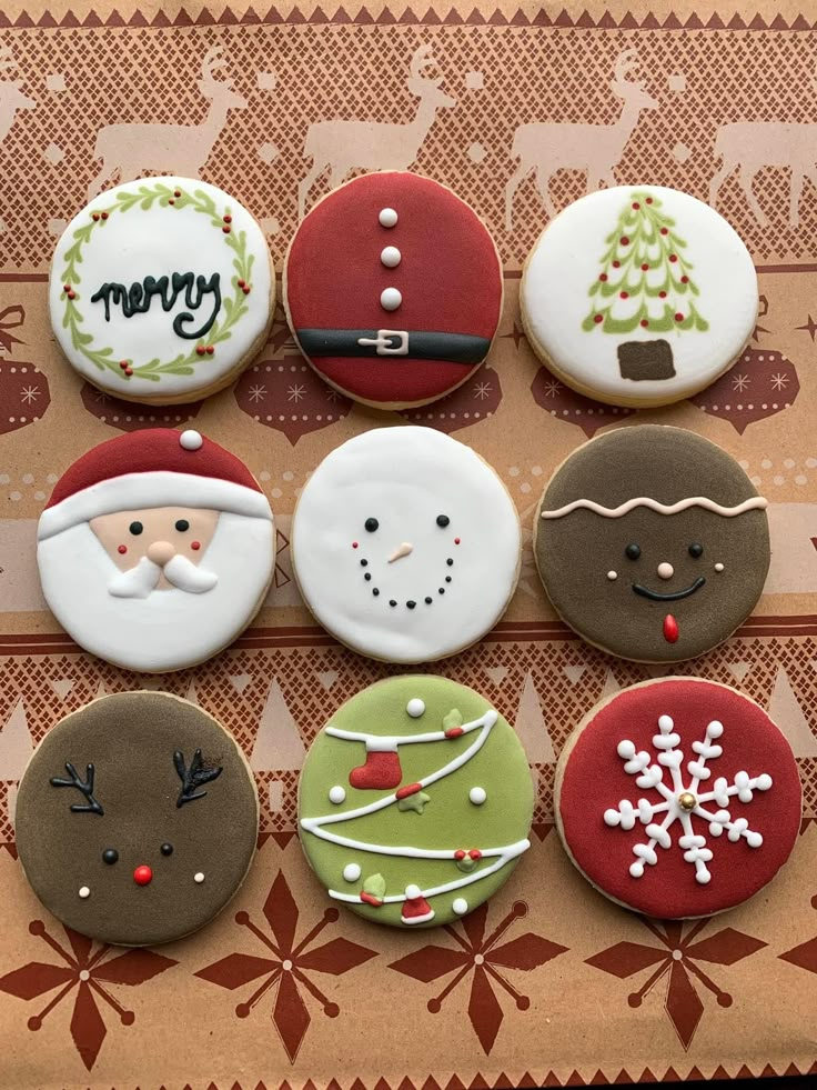 twelve decorated christmas cookies sitting on top of a table