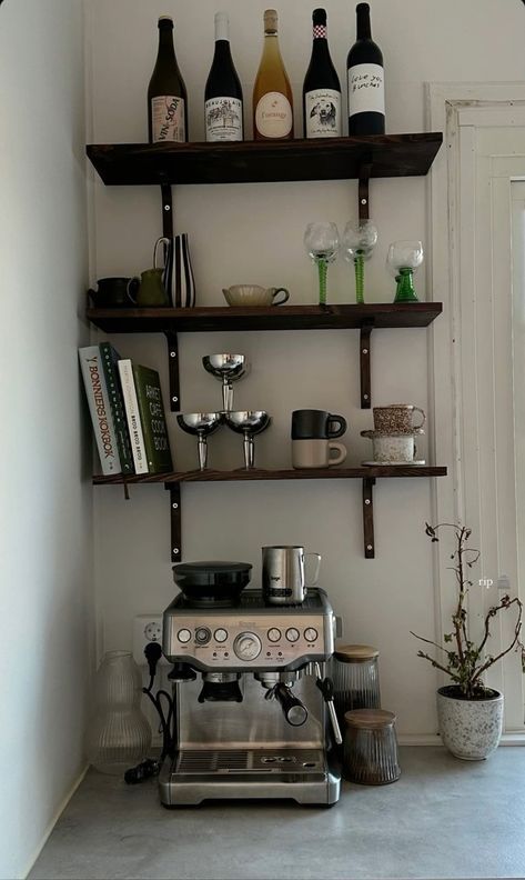 a coffee maker sitting on top of a counter next to shelves filled with wine bottles