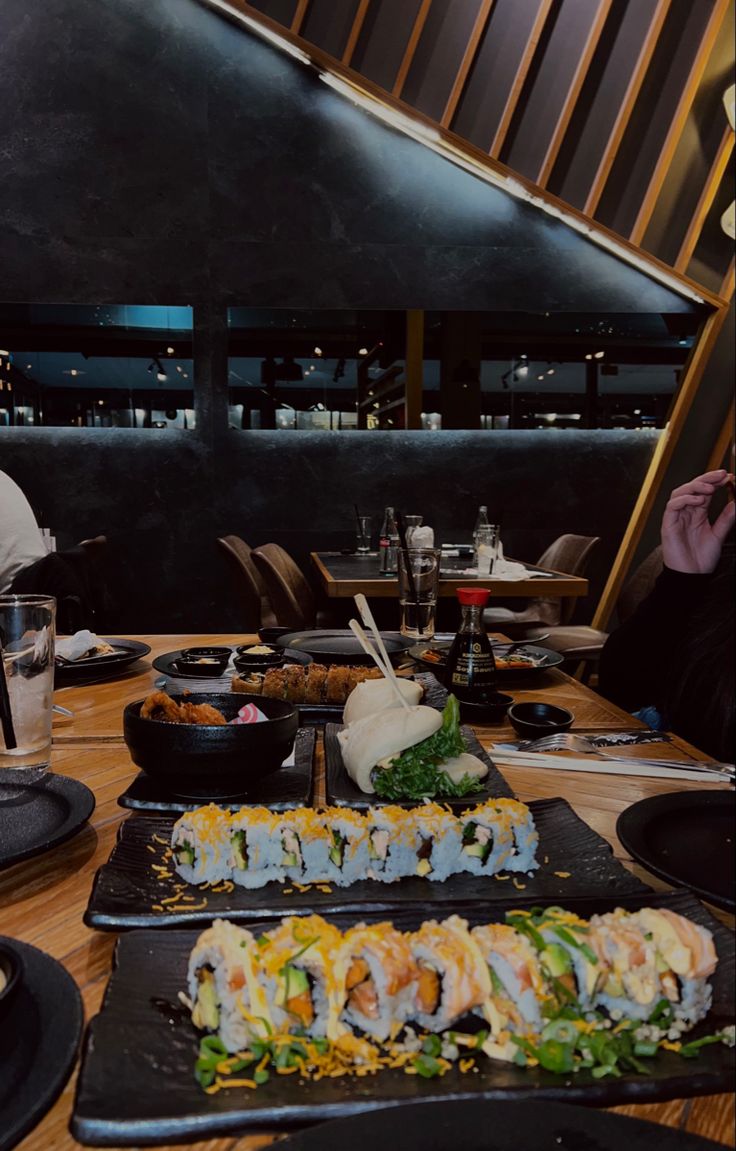 people sitting at a table eating sushi