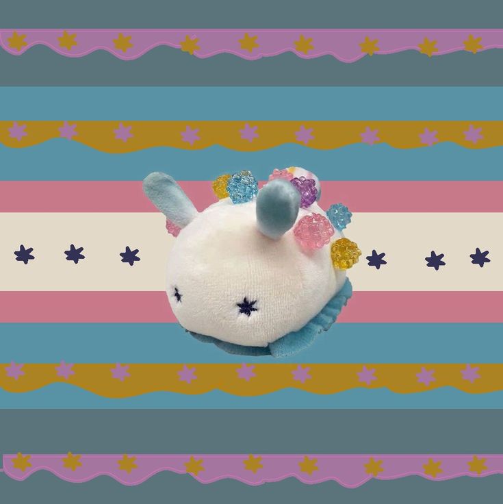 a small stuffed animal on top of a colorful striped background