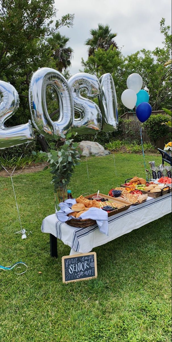 a table that has some food on it and balloons in the air with numbers above it