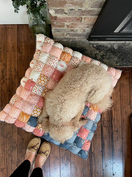 a teddy bear laying on top of a blanket next to a woman's feet