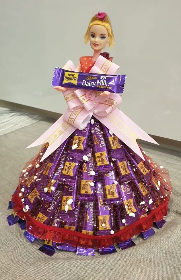 a barbie doll wearing a dress made out of candy bars