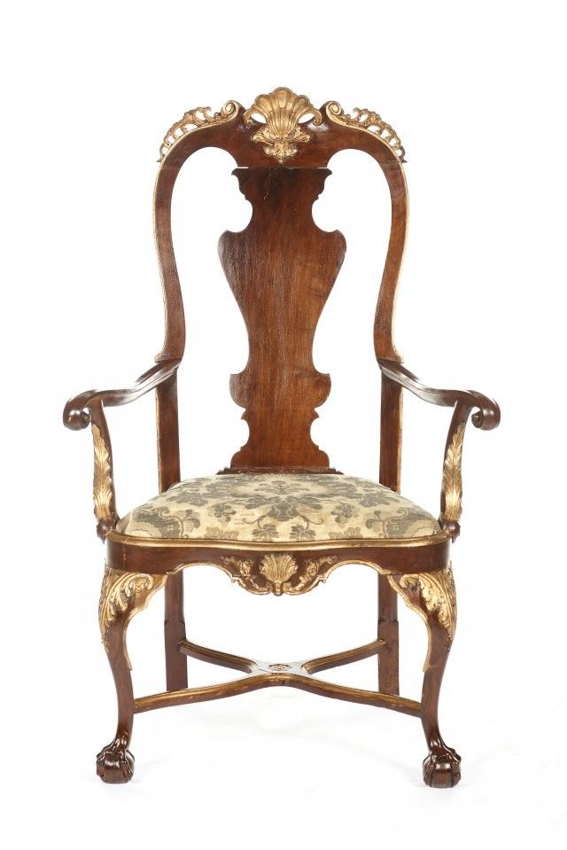 an antique wooden chair with floral upholstered seat and arm rests against a white background