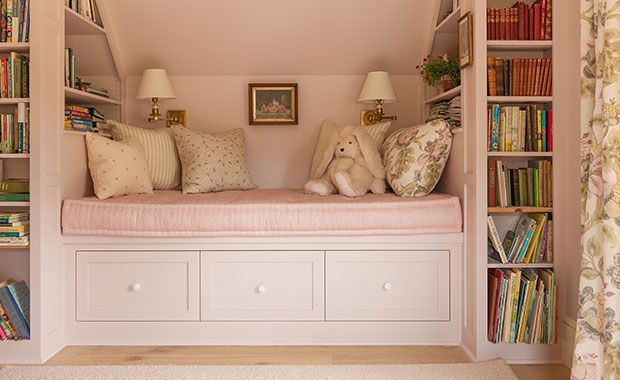 a room that has some bookshelves with stuffed animals on them