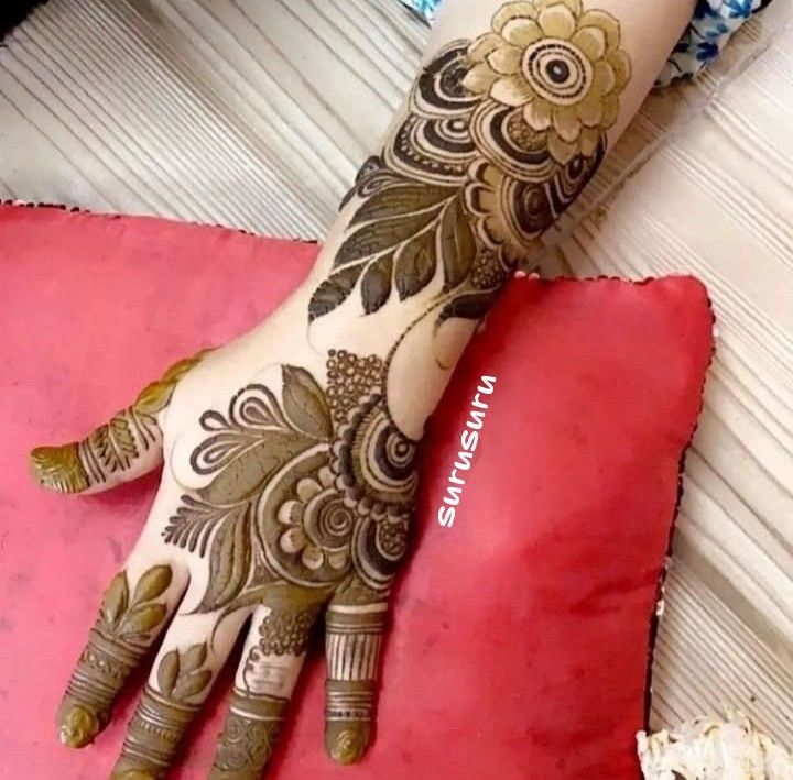 a woman's hand with henna on top of her arm and foot,